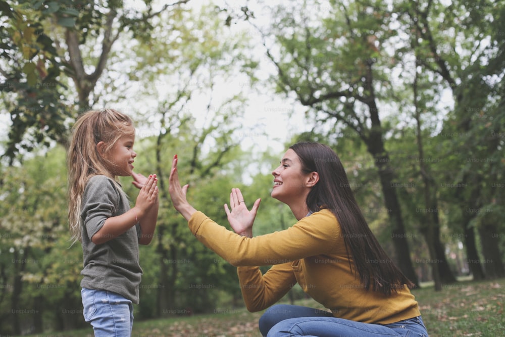 Mother playing with daughter with hands.