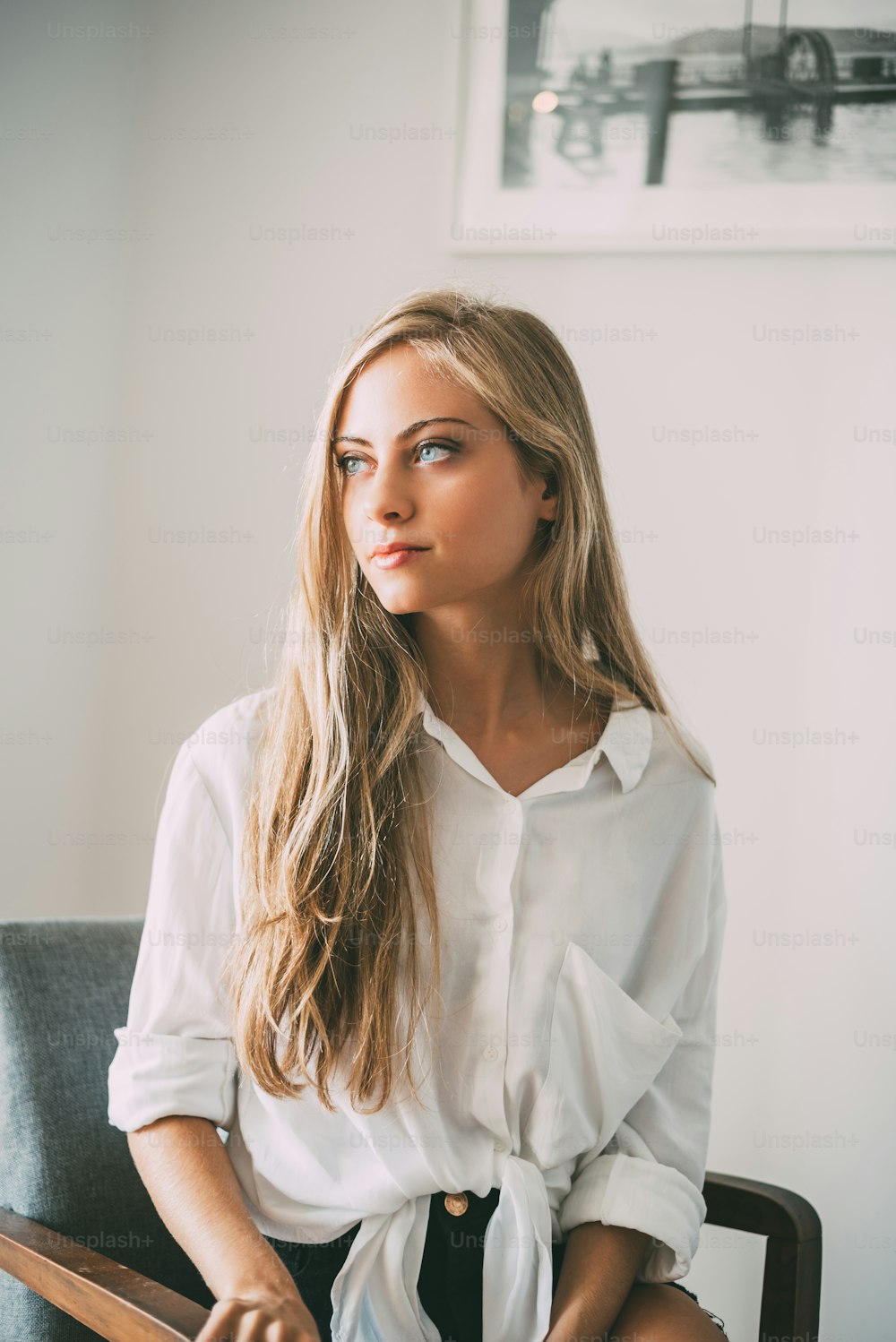Porträt einer jungen, nachdenklichen blonden Frau sitzend