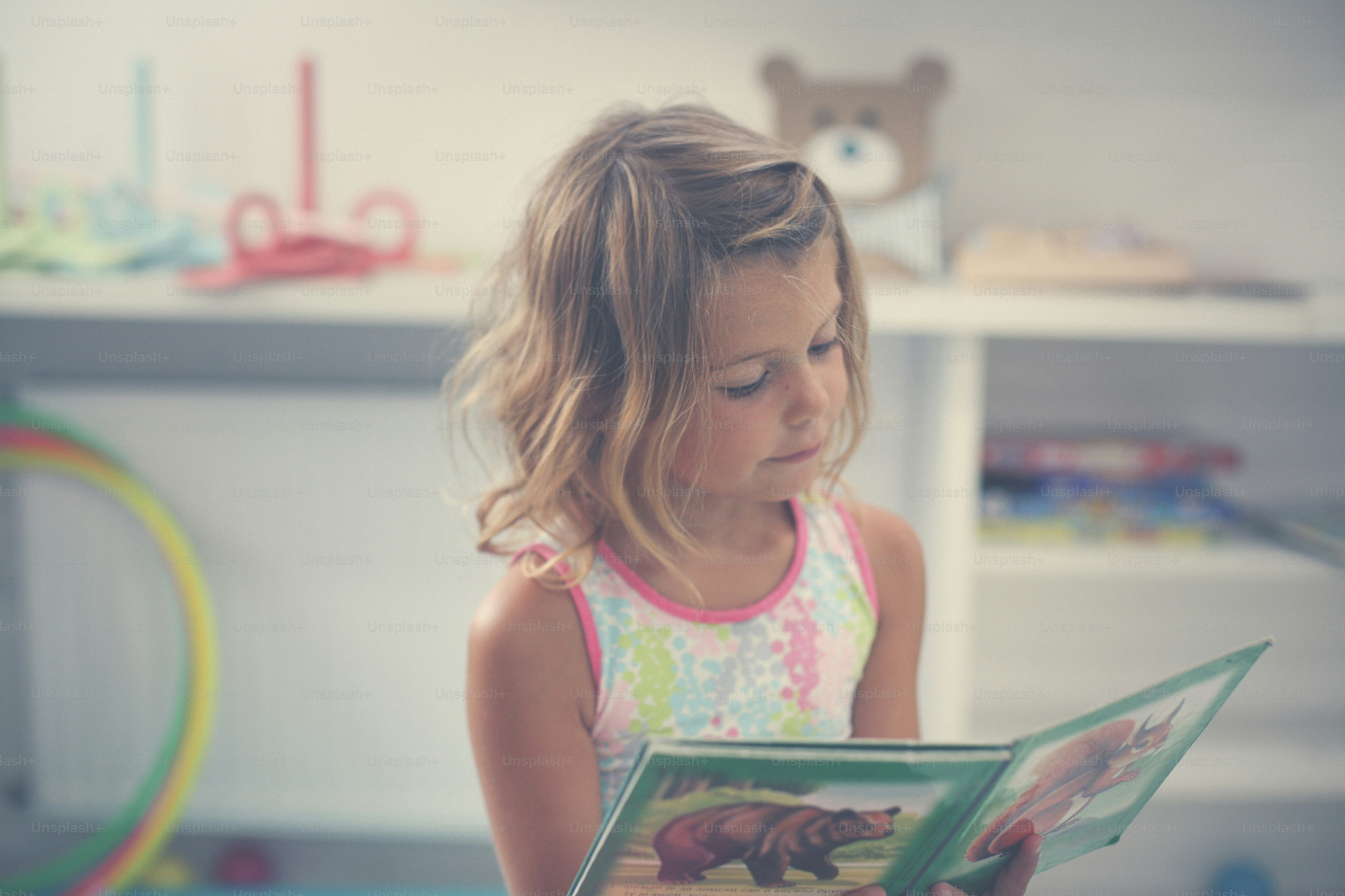 Little girl in playground. Little girl reading picture book.