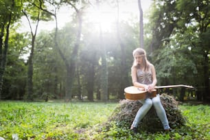 Donna con il cuore spezzato nella natura con la chitarra combatte la depressione