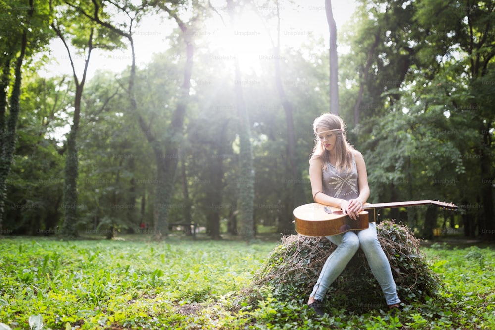 Heartbroken woman in nature with guitar battles depression