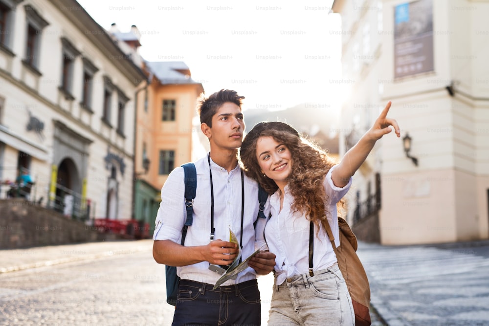 Dos hermosos turistas jóvenes con mapa y cámara en el casco antiguo