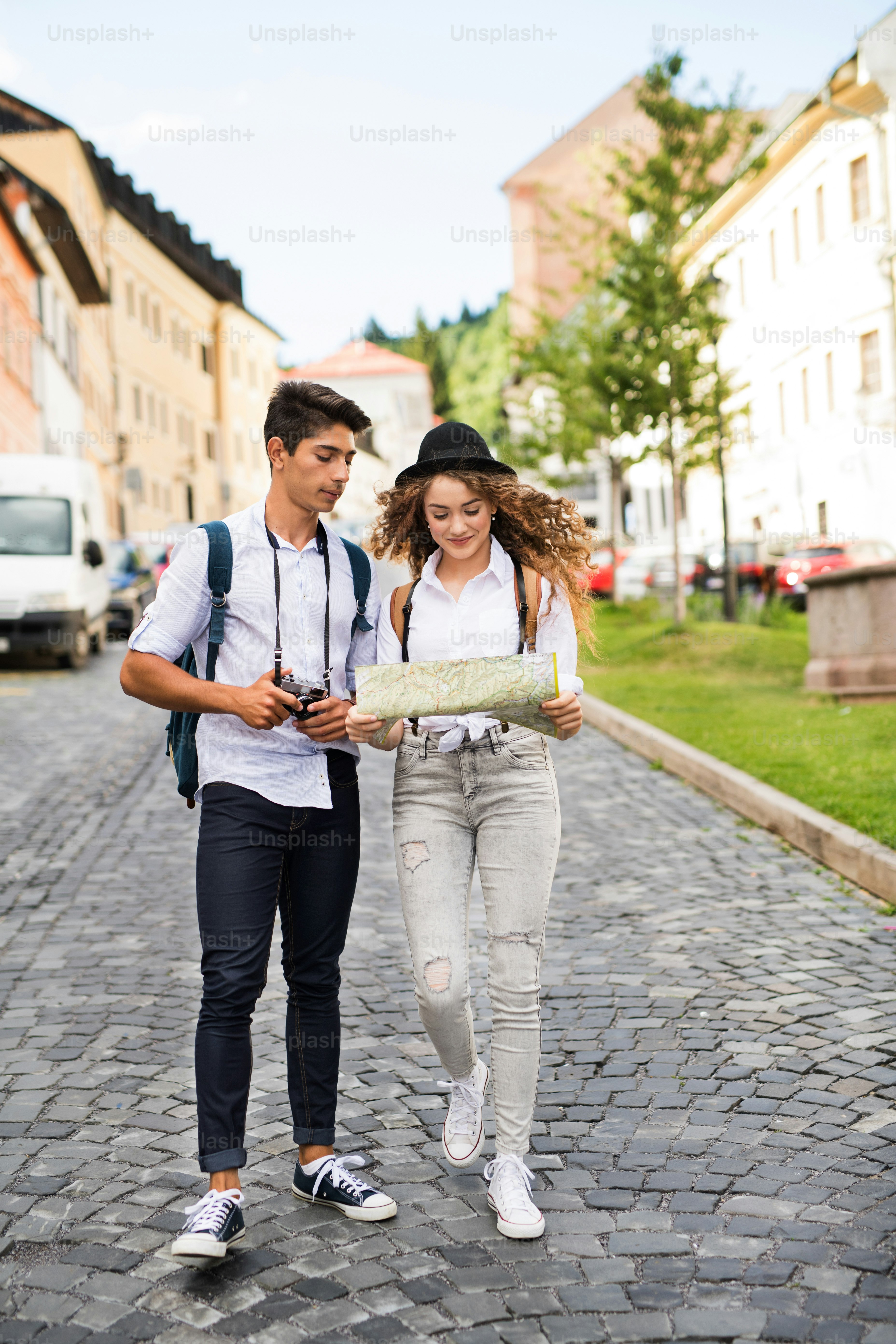 Foto Dos hermosos turistas jóvenes con mapa y cámara en el casco ...