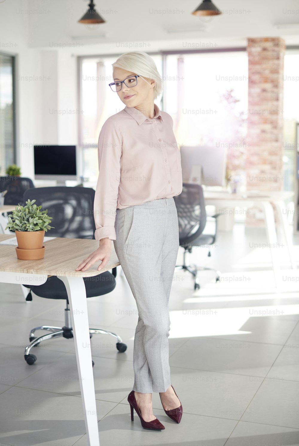 Business person leaning against office desk