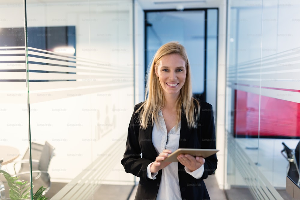 Retrato de una mujer de negocios exitosa sosteniendo una tableta digital en la oficina