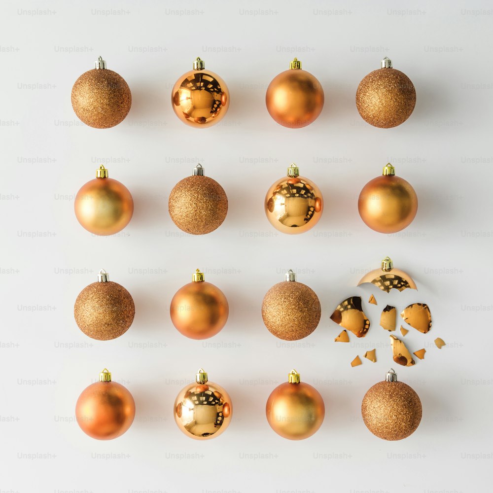 Golden Christmas baubles decoration on bright background. Flat lay. Holiday concept.