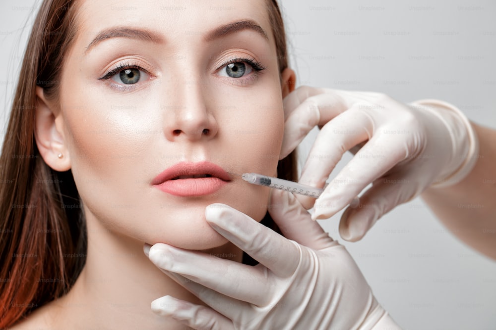 Portrait of beautiful woman getting injection on lips. beauty injections and cosmetology