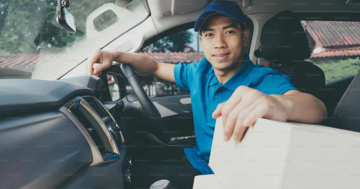Driver Delivery Pusing Delivery driver driving car with packages on seat outside the warehouse ...