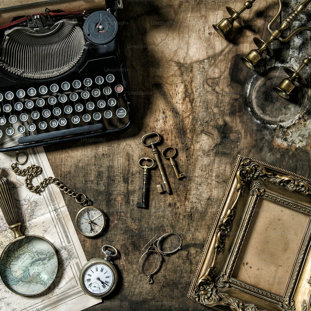 Máquina de escribir antigua y herramientas de oficina vintage sobre mesa de madera. Bodegón nostálgico