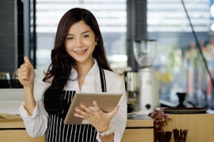 Portrait of asian young woman cafe owner with tablet.