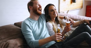 Romantic couple in love drinking beer together and watching tv