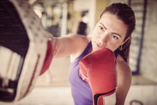 Woman boxer hitting the glove of his sparring partner.