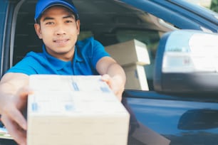 Delivery driver offering parcel to customer.
