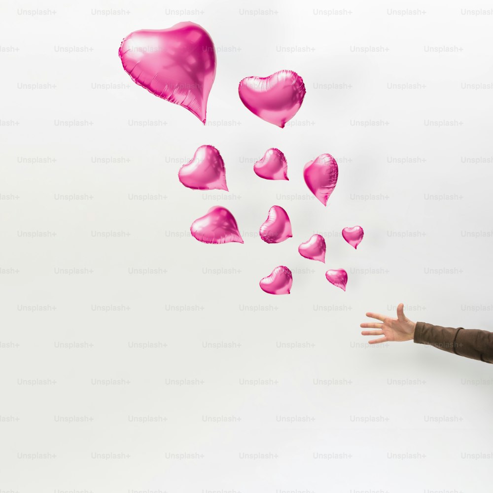 Heart shaped balloons floating away. Minimal love concept.