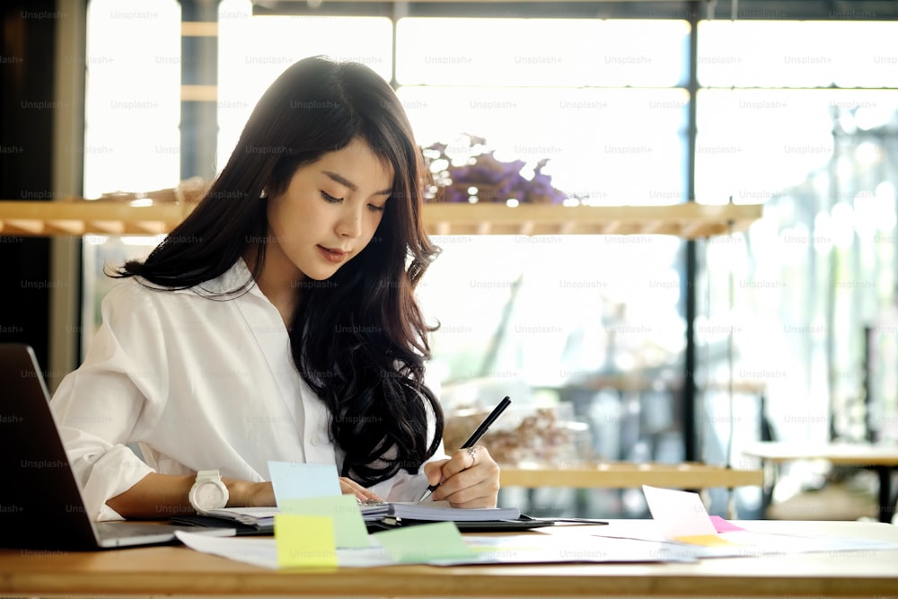 Shot of an attractive young woman sitting at home in front of her laptop