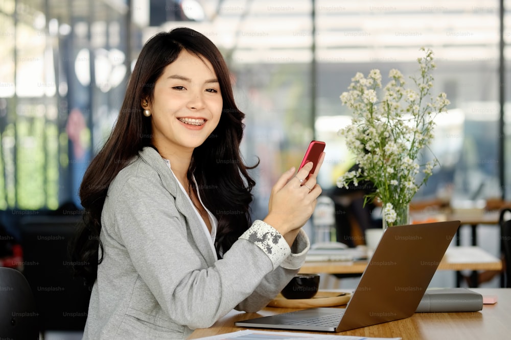 Shot of a young businesswoman using mobil phone while working in an office.