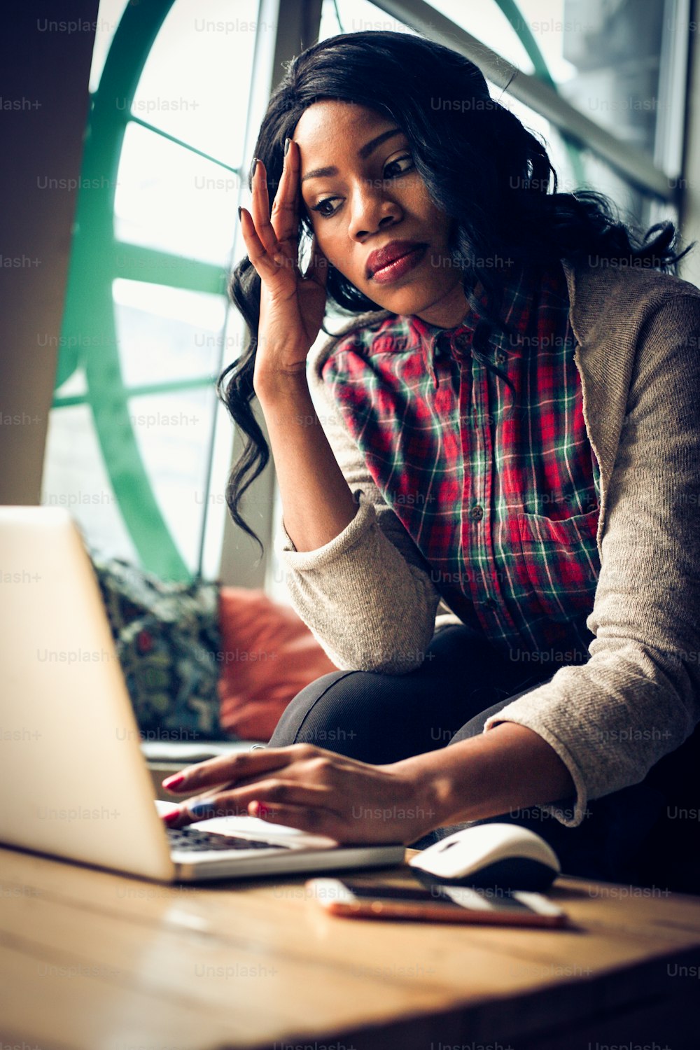 Mujer de negocios afroamericana trabajando en computadora portátil.