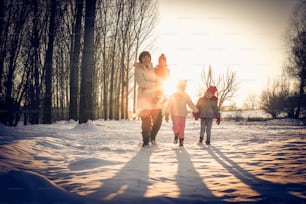 Happy grandmothers enjoying their grand children outside in winter - family portrait.