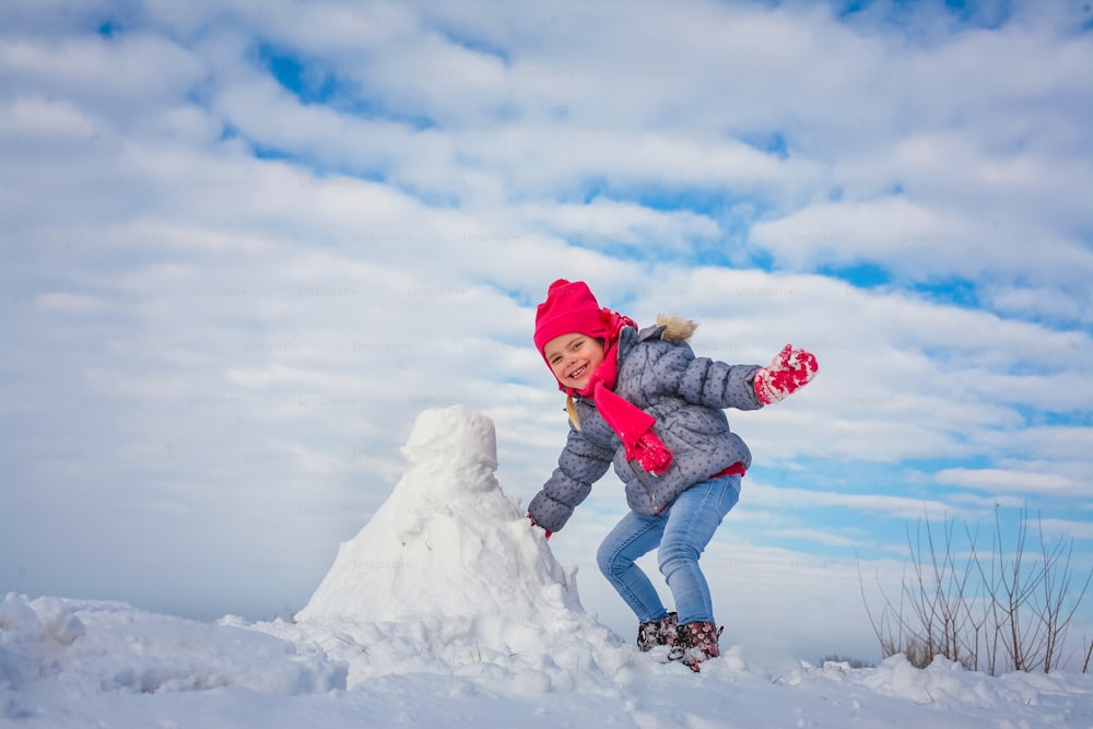 One grill making snowman. Looking at camera.