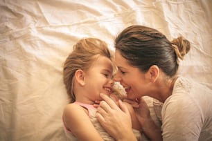 Young  mother and daughter laying in bed.