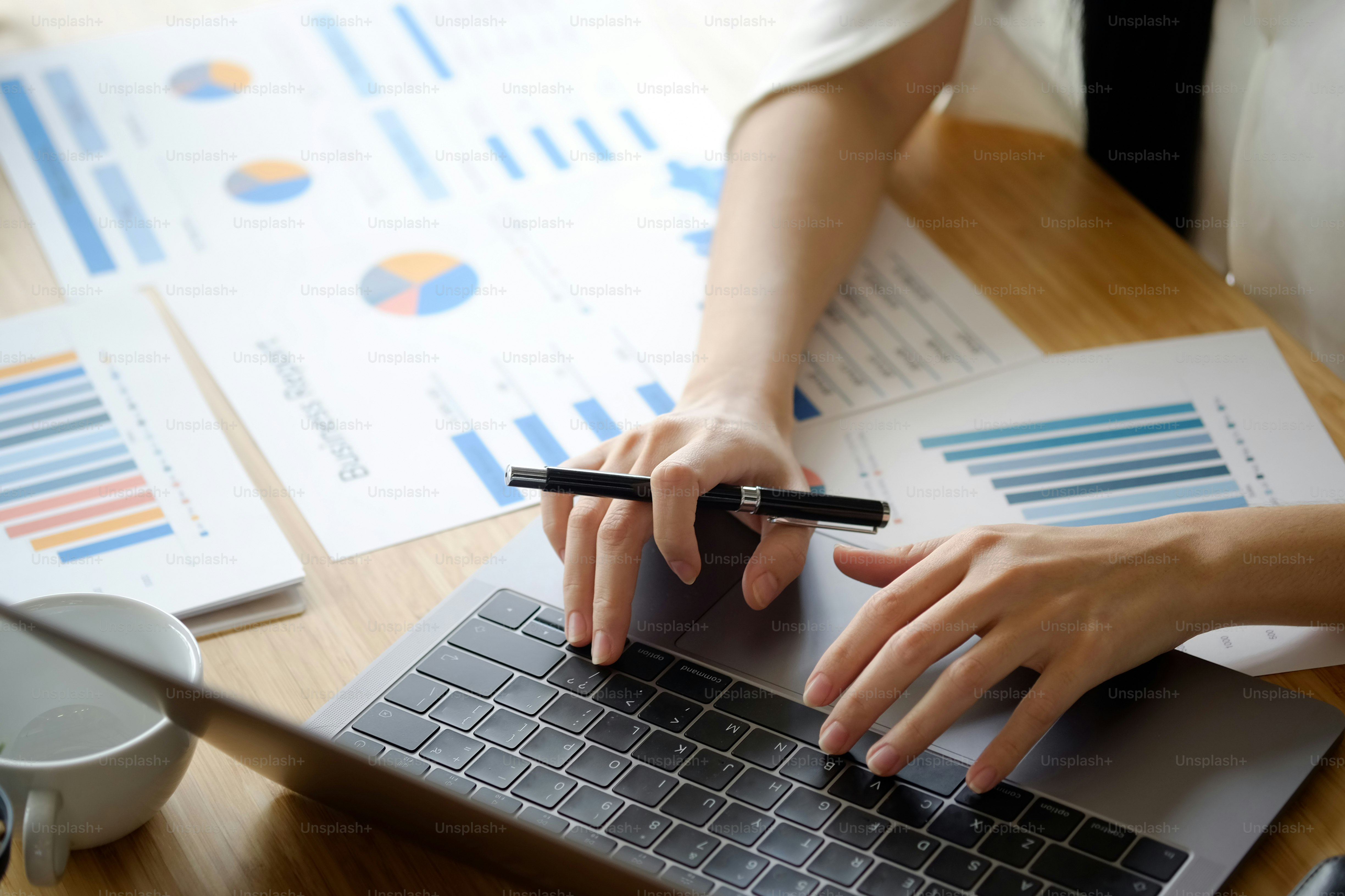 Cropped shot of an unrecognizable woman working on her laptop and paper at office.