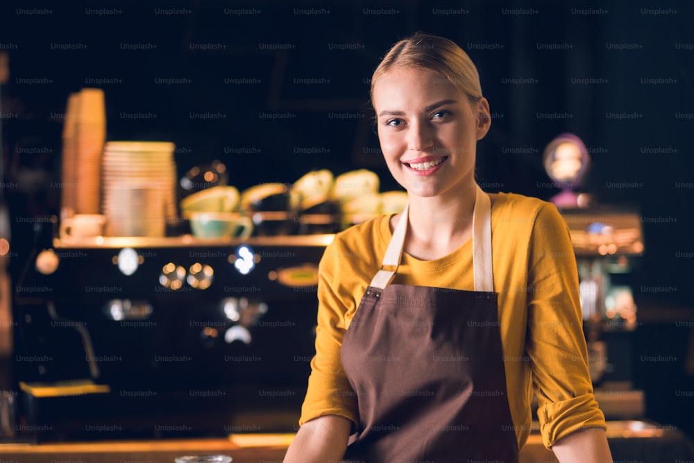 Portrait of outgoing young female barista having job in cafe. Occupation concept. Copy space