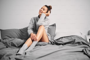 Girl posing while sitting on bed in the morning