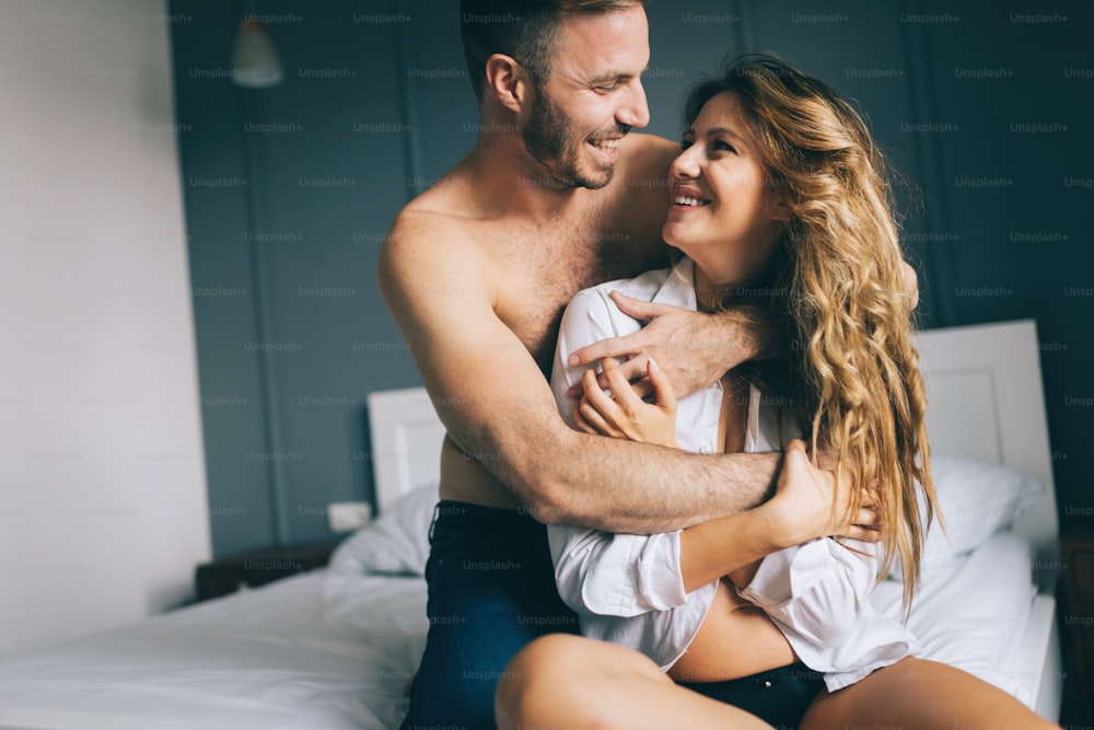 Young Attractive Couple In Love Cuddling In Bed In Bra And Tshirt