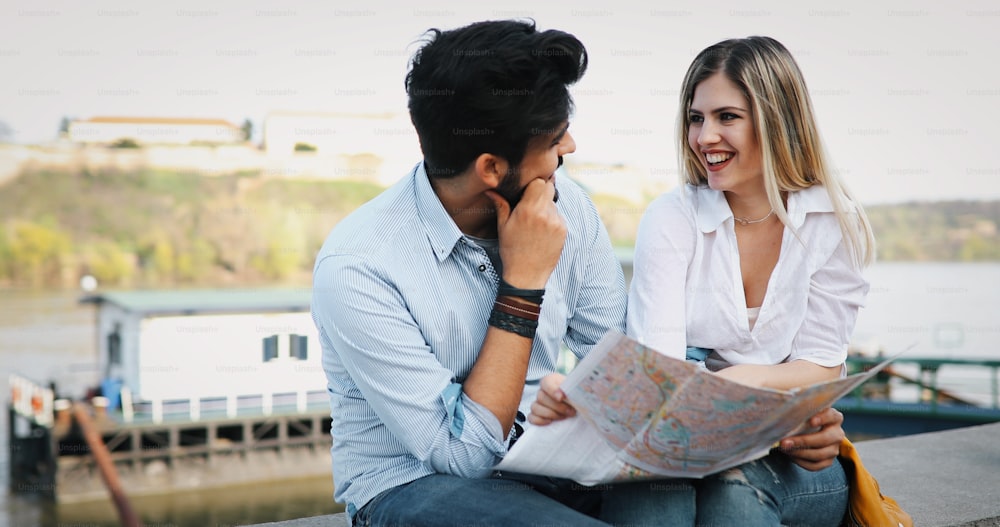Glückliches Touristenpaar, das in die Karte verliebt ist und im Freien reist