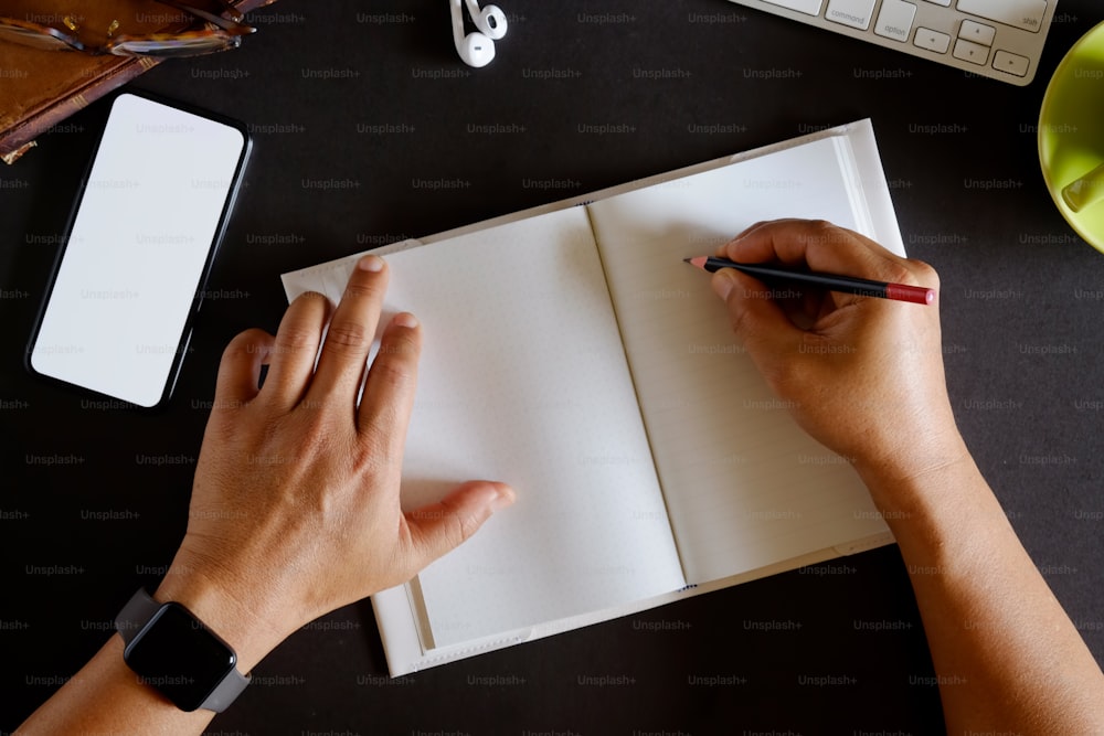 Mann Freelancer schreibt auf Notizbuch zu Hause oder im Büro.