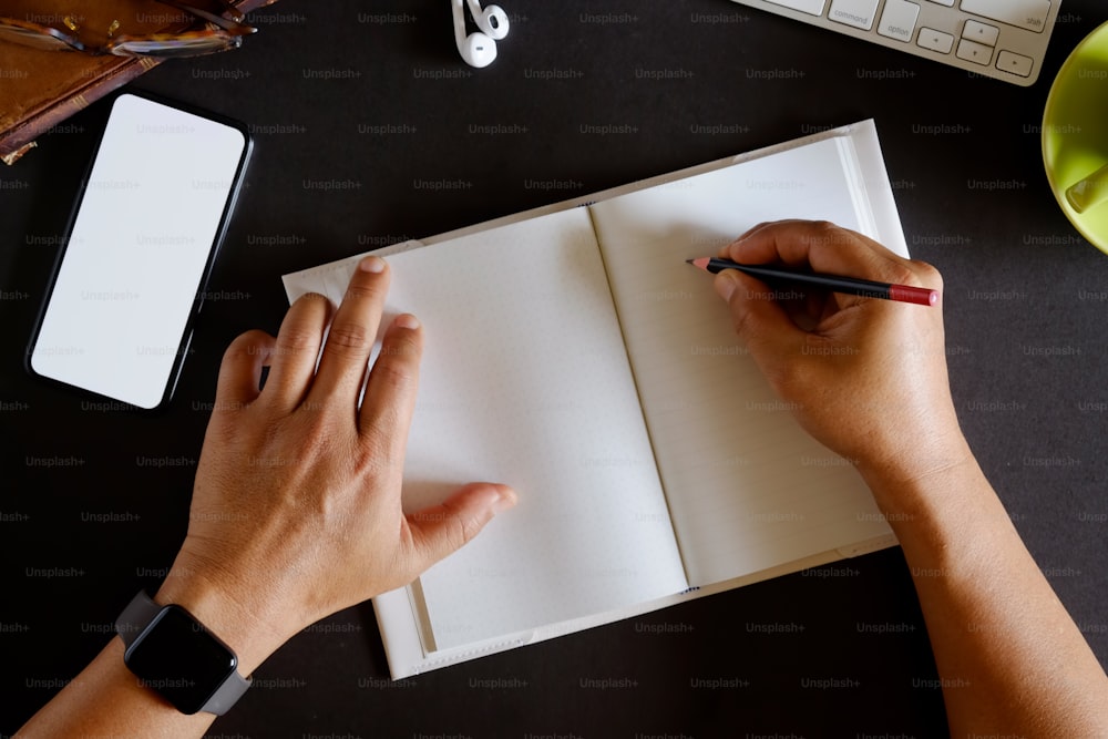 Hombre autónomo escribiendo en cuaderno en casa u oficina.