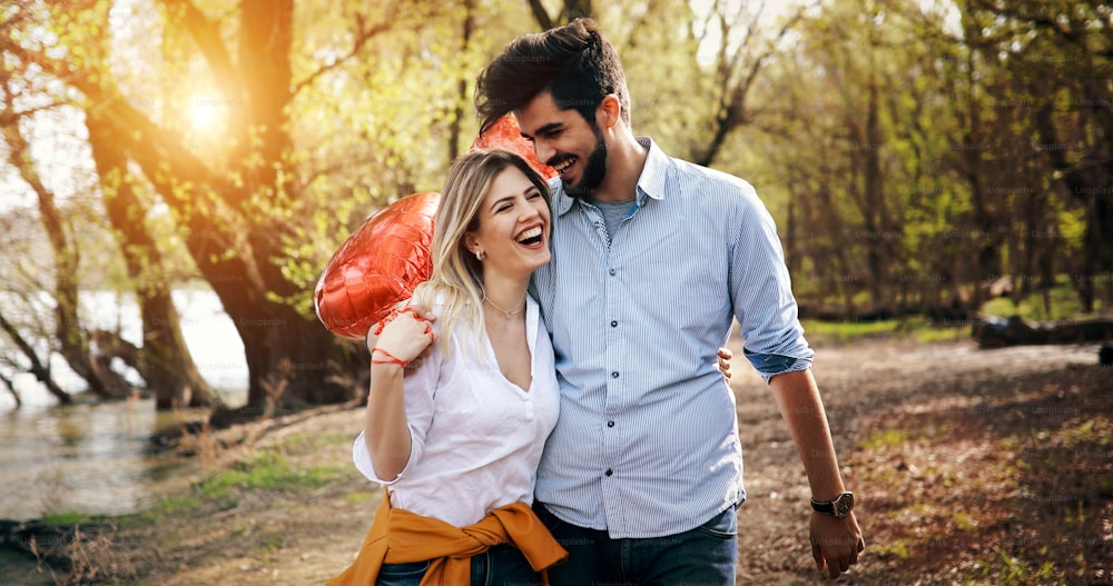 Sommerurlaub, Feier und Dating-Konzept - glückliches Paar mit bunten Luftballons