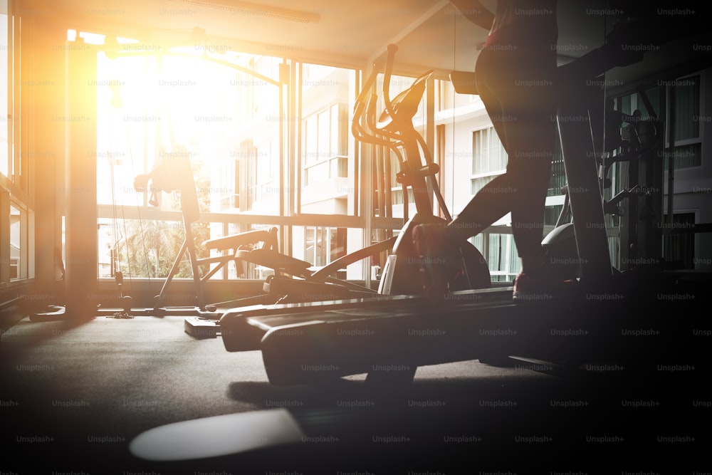 Imagen de silueta para mujer corriendo en un gimnasio en un concepto de cinta de correr para hacer ejercicio, fitness y estilo de vida saludable. acción del movimiento.