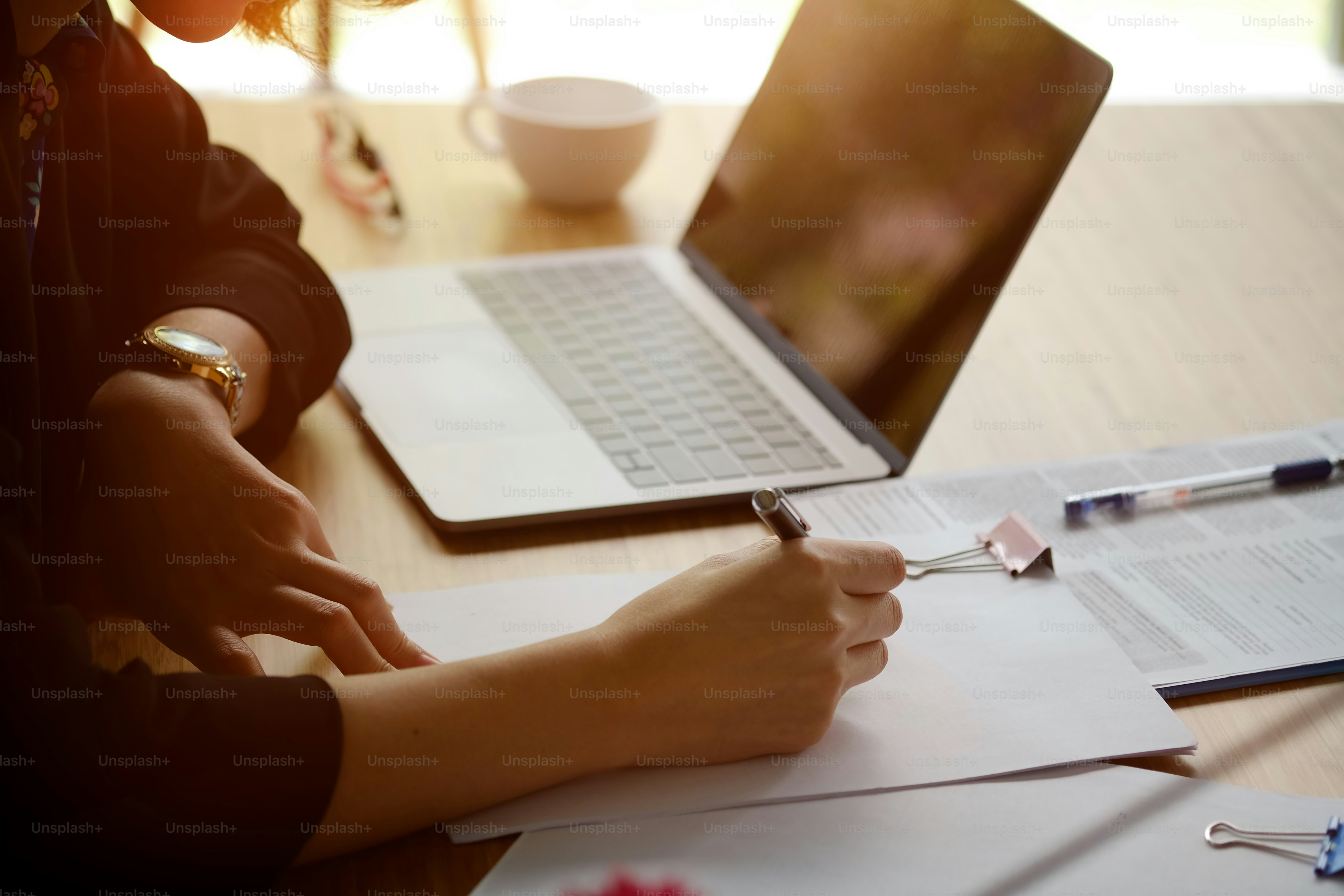 Cropped shot of an unrecognizable businesswoman making notes in cafe.