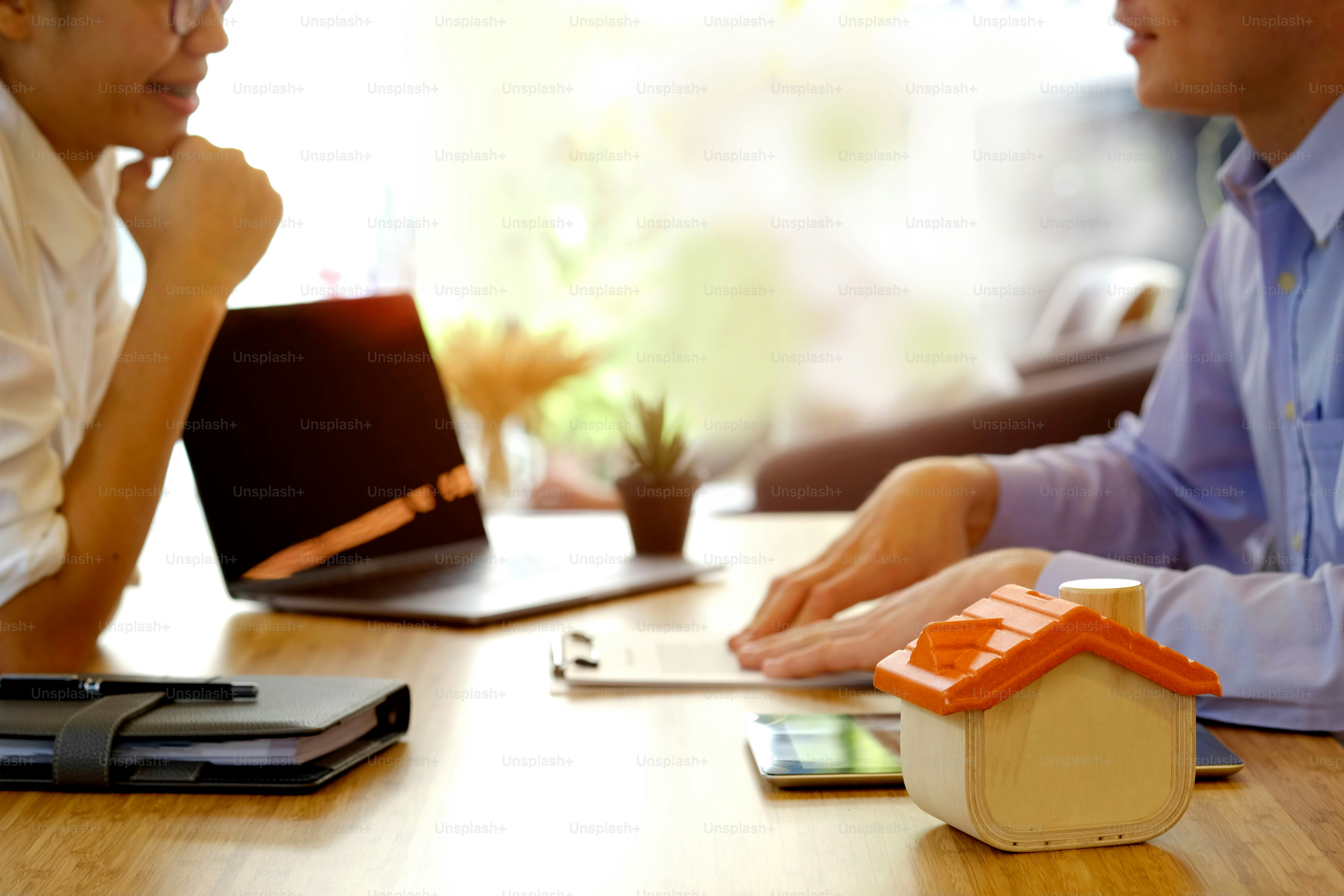 Financial advisor in discussion with a young asian woman for house loan.