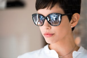 Young beautiful woman at optician with glasses buying fashion sunglasses