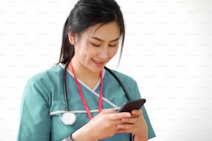 Cropped shot of an Asian doctor texting on smartphone white background.