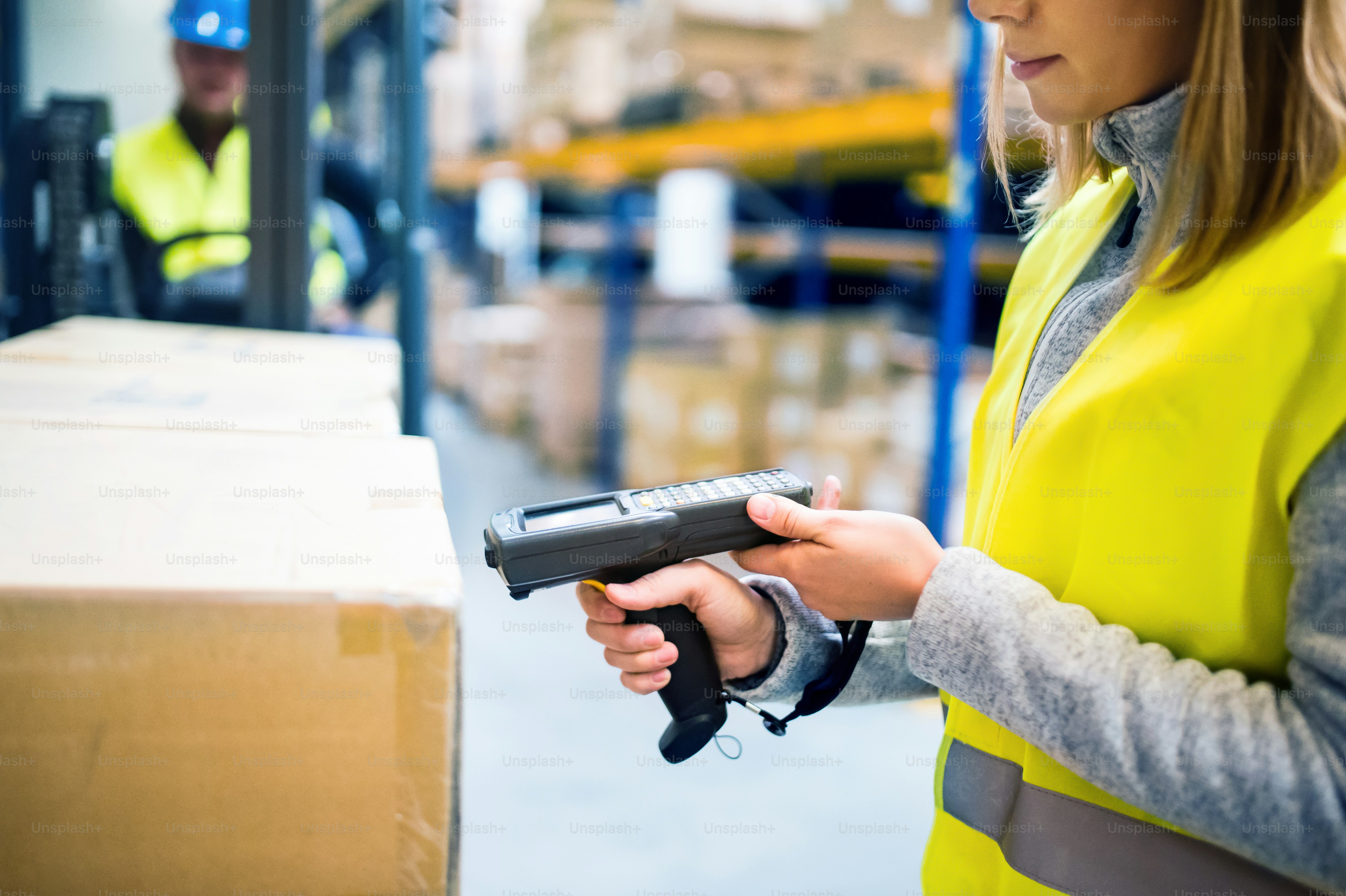 Unrecognizable warehouse woman worker or supervisor with barcode scanner. A mobile handheld PC with barcode scanner