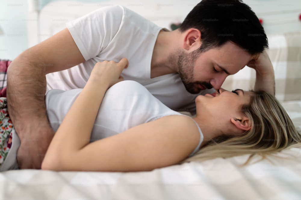 Young attractive happy couple having romantic time in bed