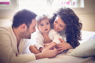 Portrait of young parents with little girl.