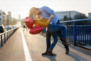 Beautiful couple in love cuddling while enjoying beautiful urban sunset together