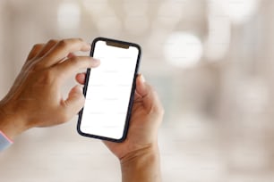 man showing blank screen mobile phone over blurred background.