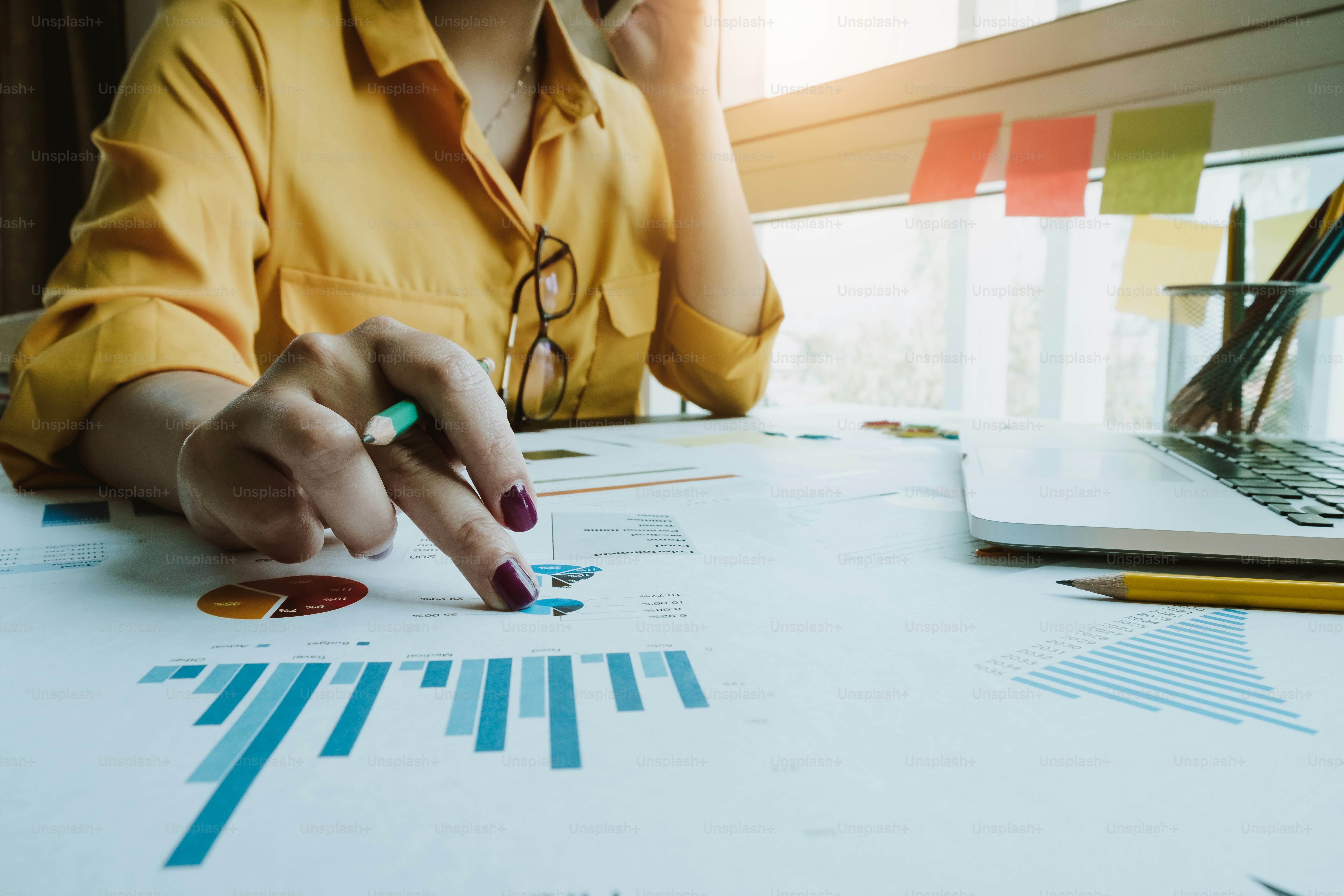 Businesswoman analysis financial document with laptop computer during call consultant - Business concept