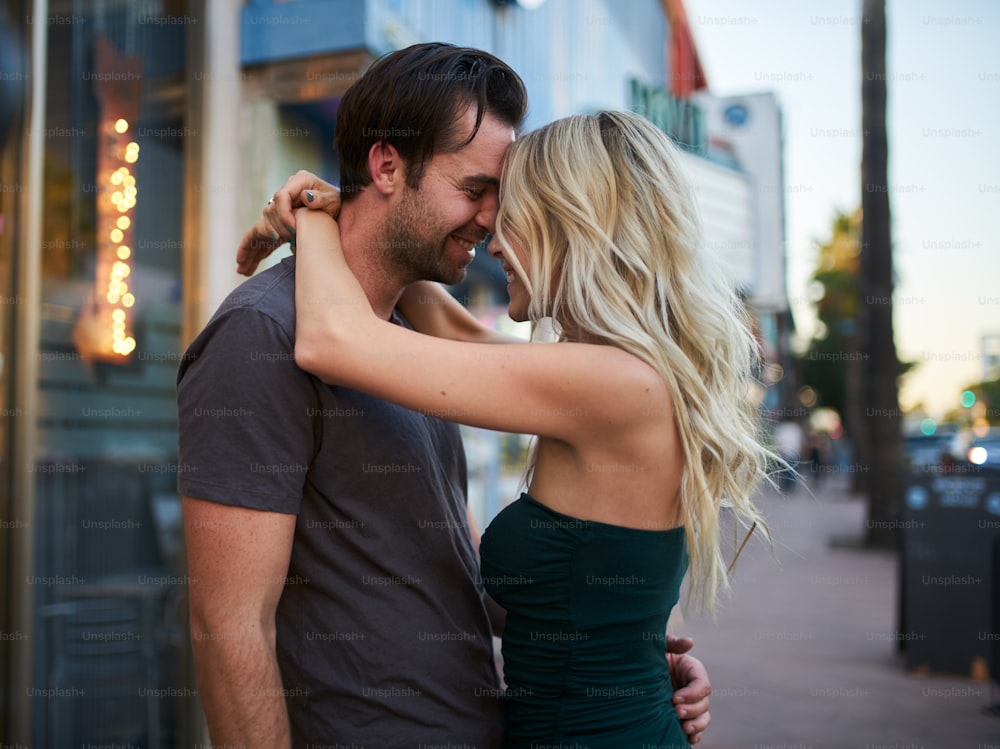 romantic moment between lovely couple on city sidewalk in los angeles