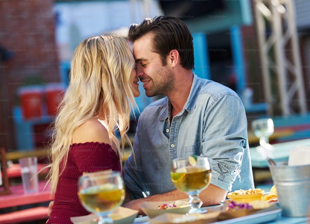 couple kissing while on date at taco restaurant with tilted composition