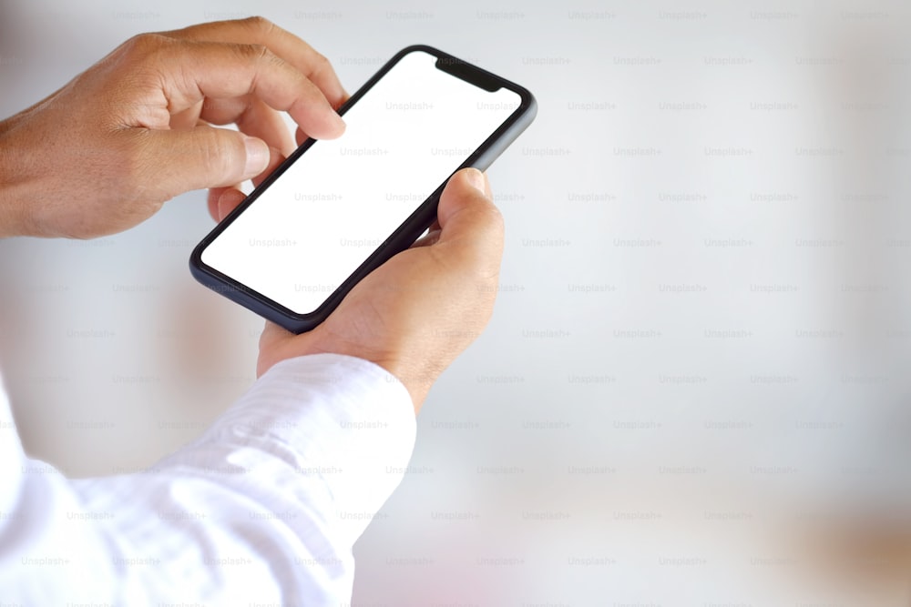 man showing blank screen mobile phone over blurred background.