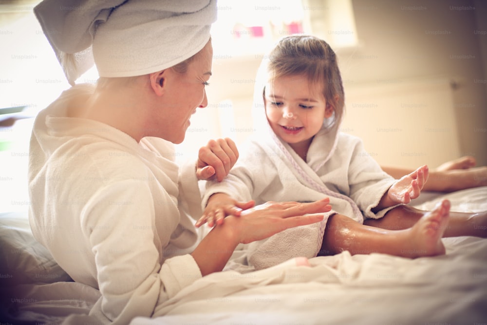 Mommy can I apply body lotion on your hand. Little girl.