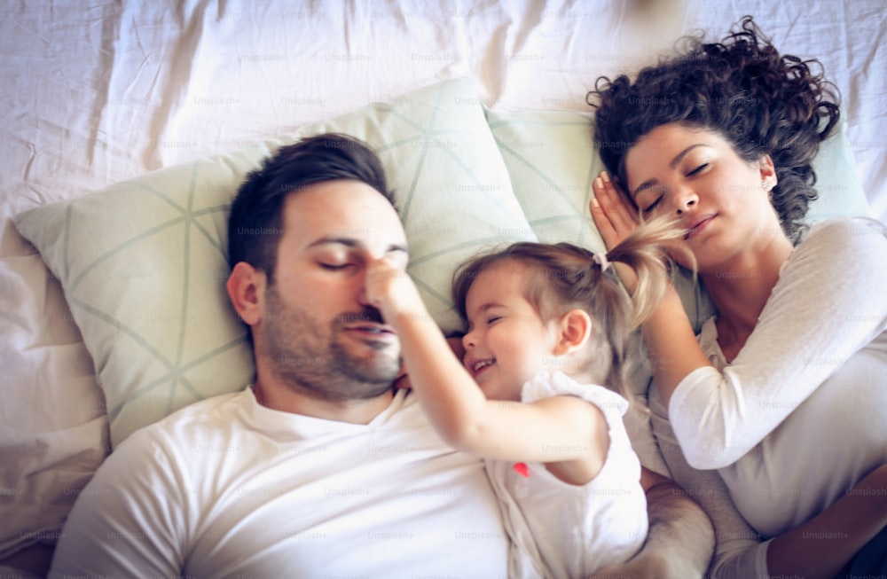 Young family sleeping in bed together.