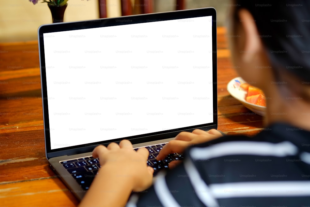 Weibliche Hände tippen Laptop-Computer zeigt leeren Bildschirm auf dem Tisch