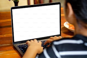 Female hands typing laptop computer showing blank screen on table